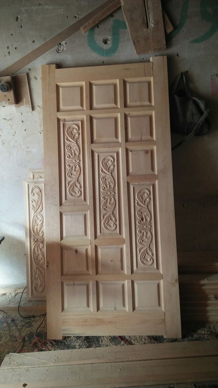 Handcrafted Solid Wood Door with Ornate Carved Panels in Workshop