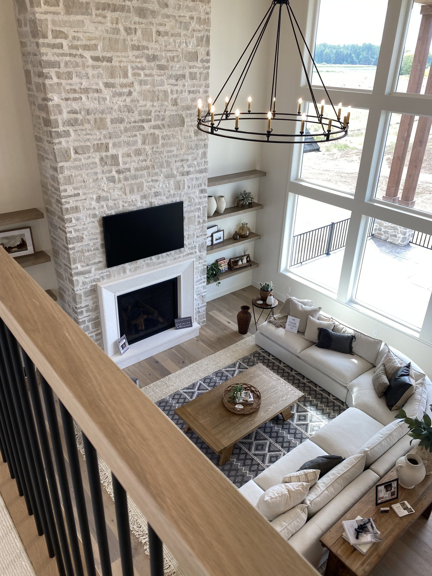 Bright Living Room With Stone Fireplace and Modern Chandelier