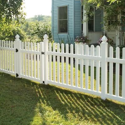 Classic White Picket Fence with Blue House Exterior