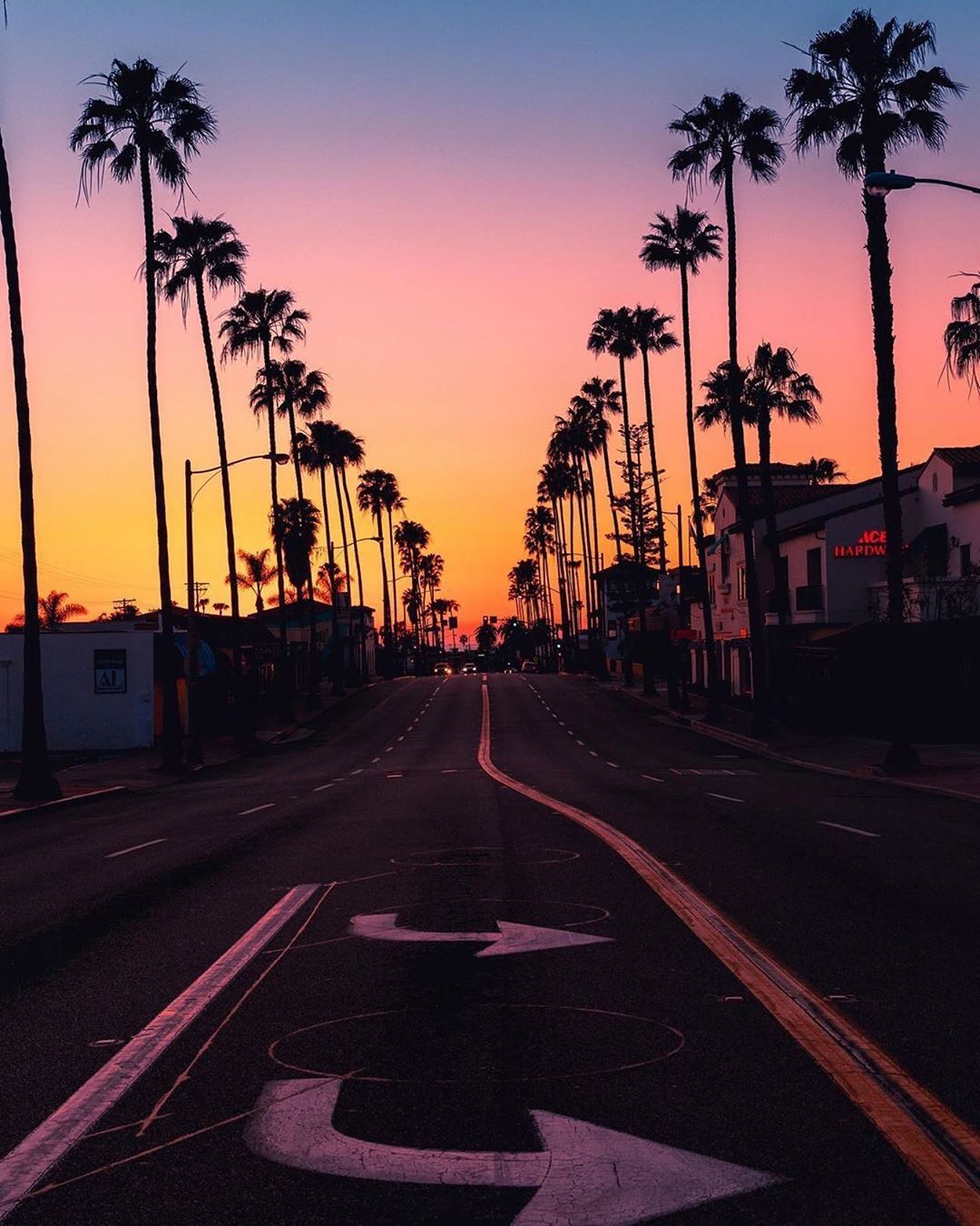 Palm-Lined Urban Street at Sunset with Vibrant Sky Colors